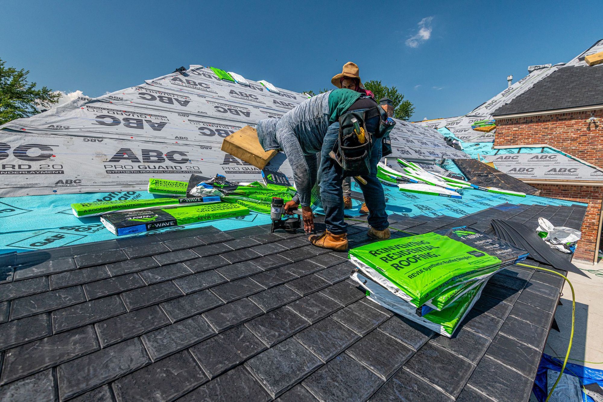 Roofing crew working across a deck of new underlayment