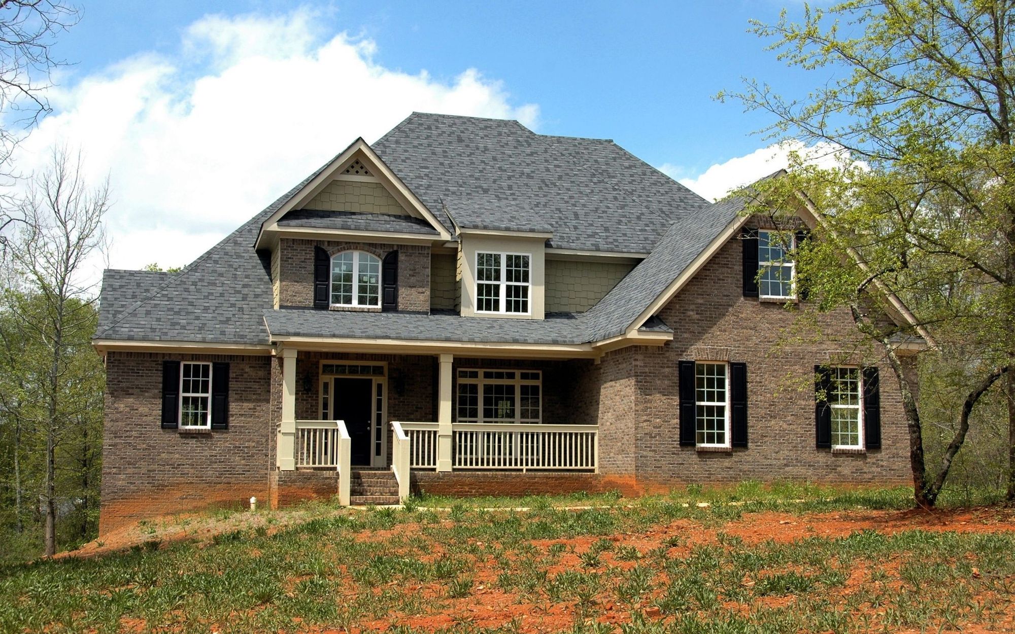 Two-story brick home with a new gable roof in Charlotte, North Carolina
