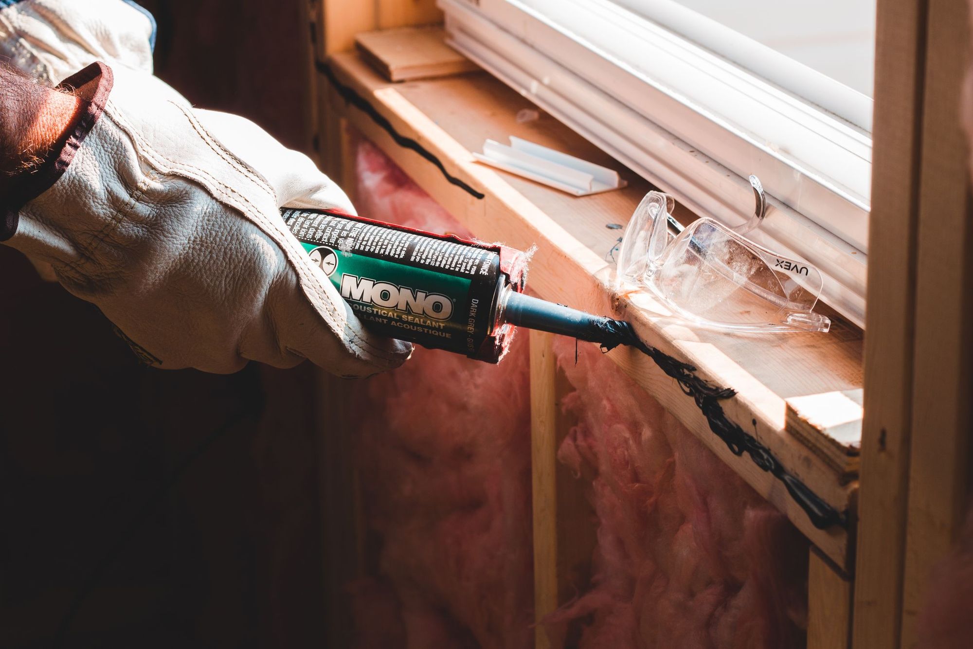 Installer caulking the seam on a newly set replacement window
