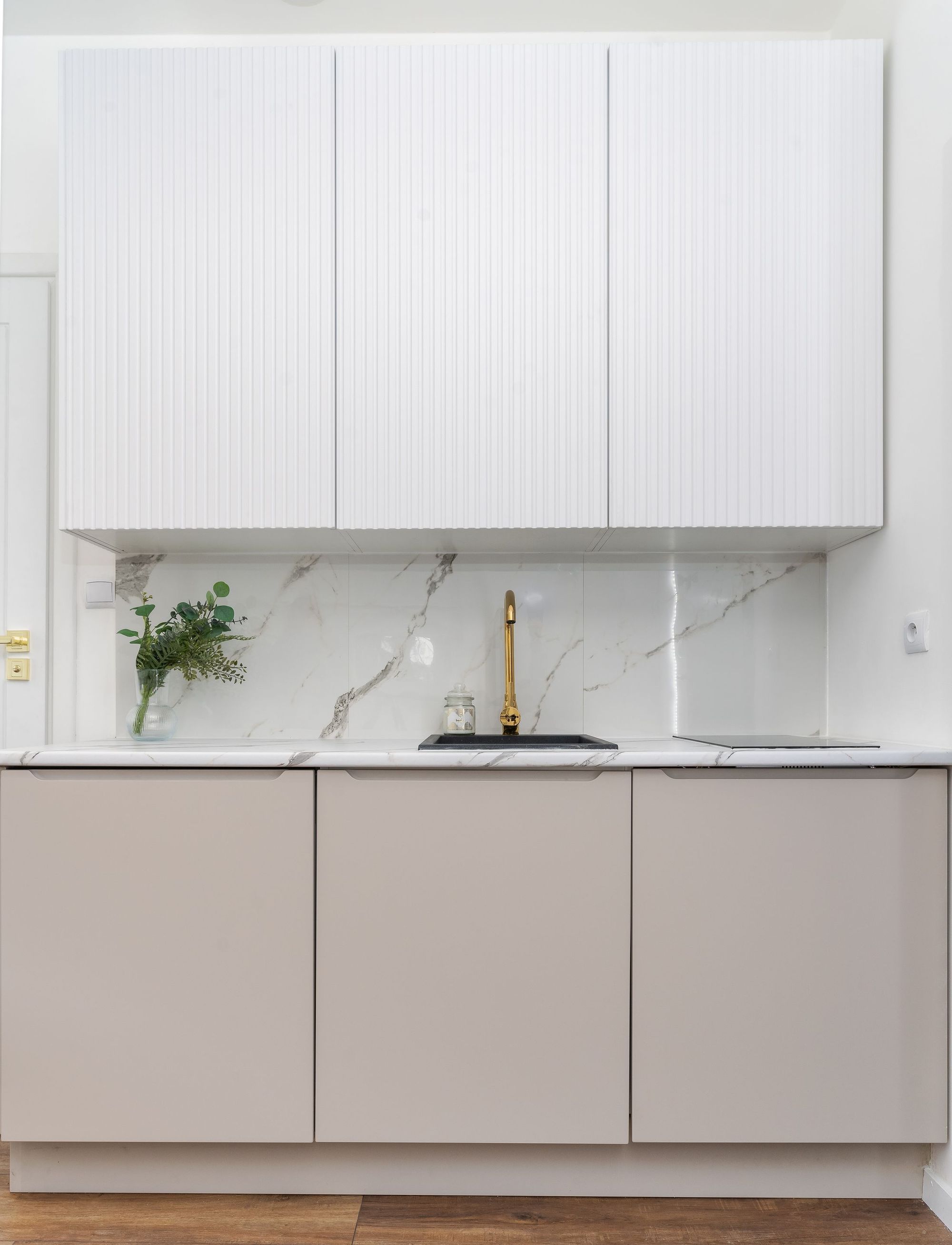 A finished Dovetail kitchen in Myers Park, Charlotte: white marble, warm wood, brass