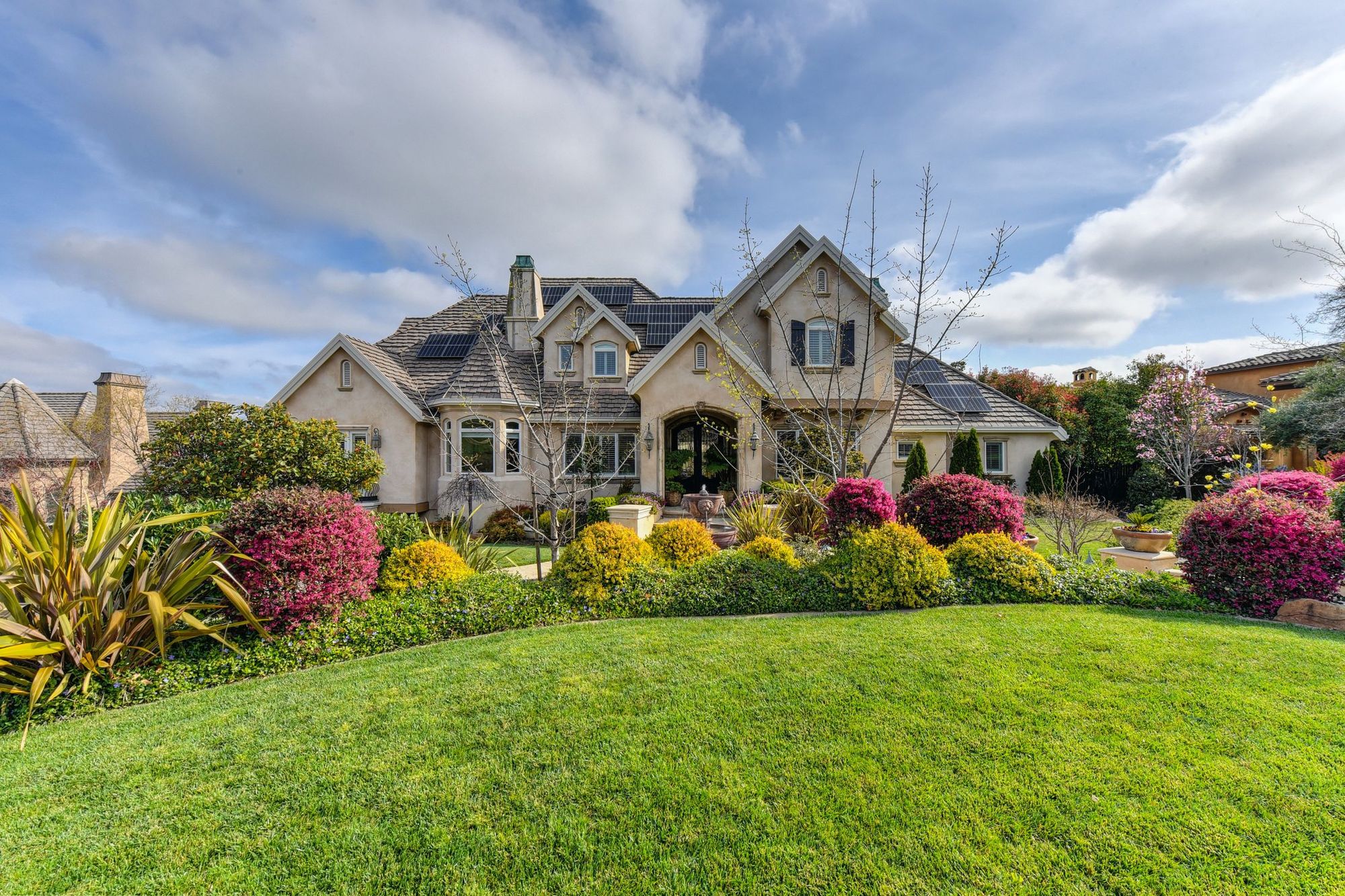 Front yard with layered beds, flowering shrubs and a full lawn