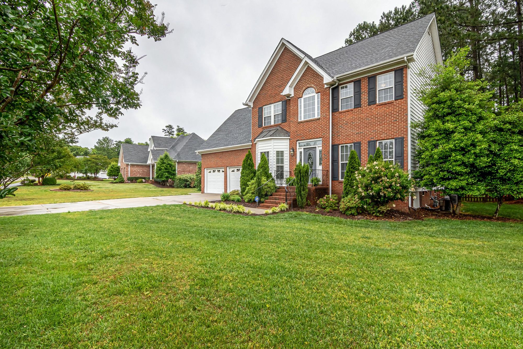 Brick two-story house with a thick, even lawn
