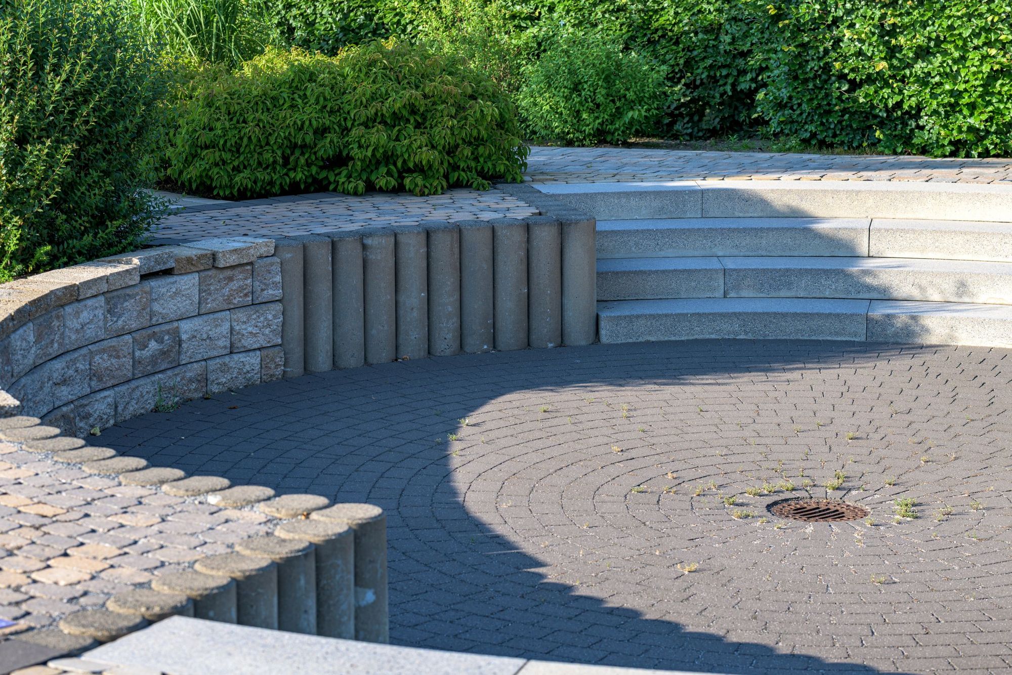 Round paver terrace with curved stone seating walls and steps