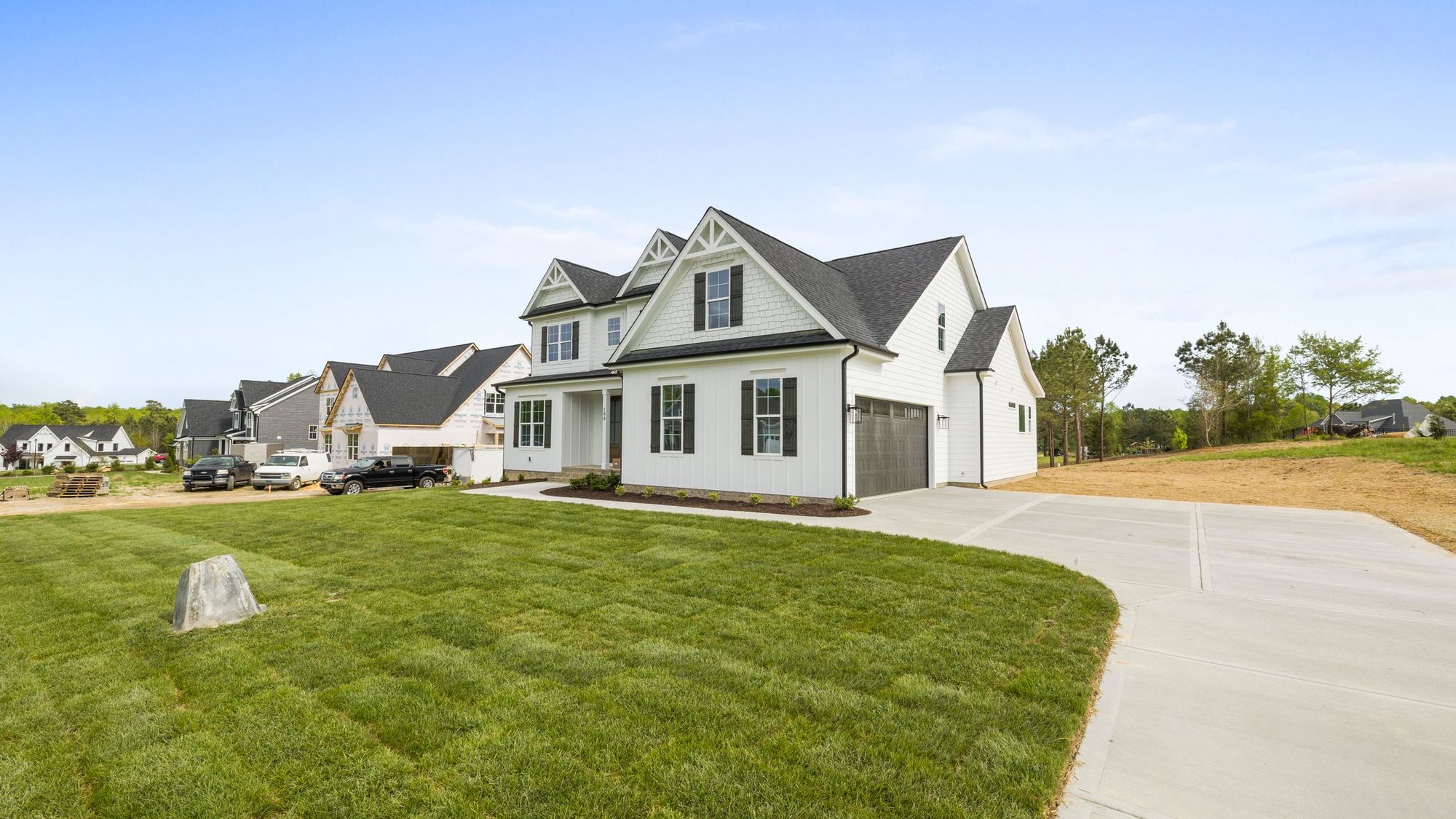 New house with a fresh sod lawn and a curving driveway
