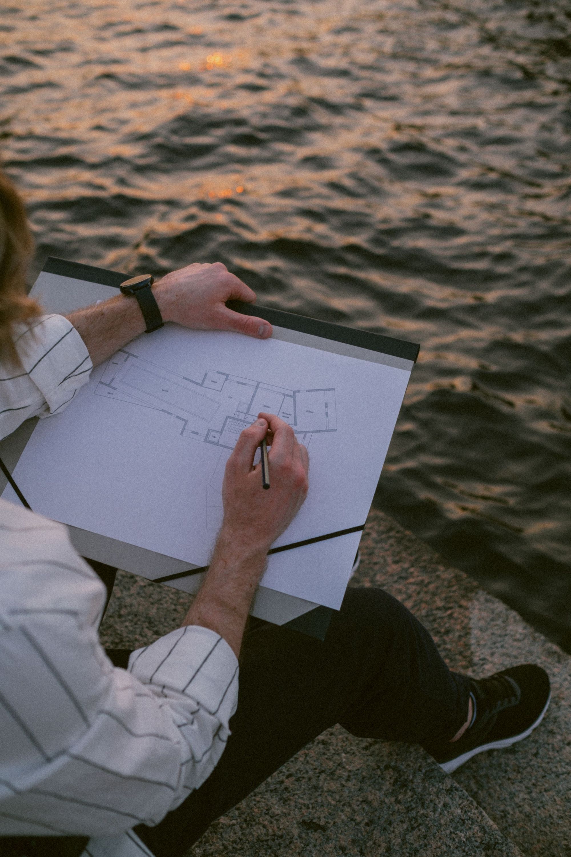 Designer sketching a site plan on paper outdoors