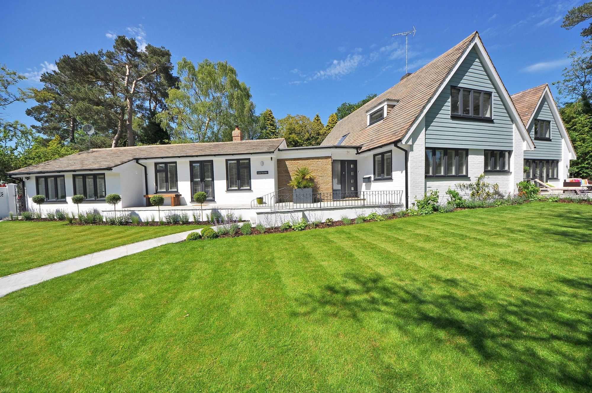 White farmhouse behind a freshly striped lawn