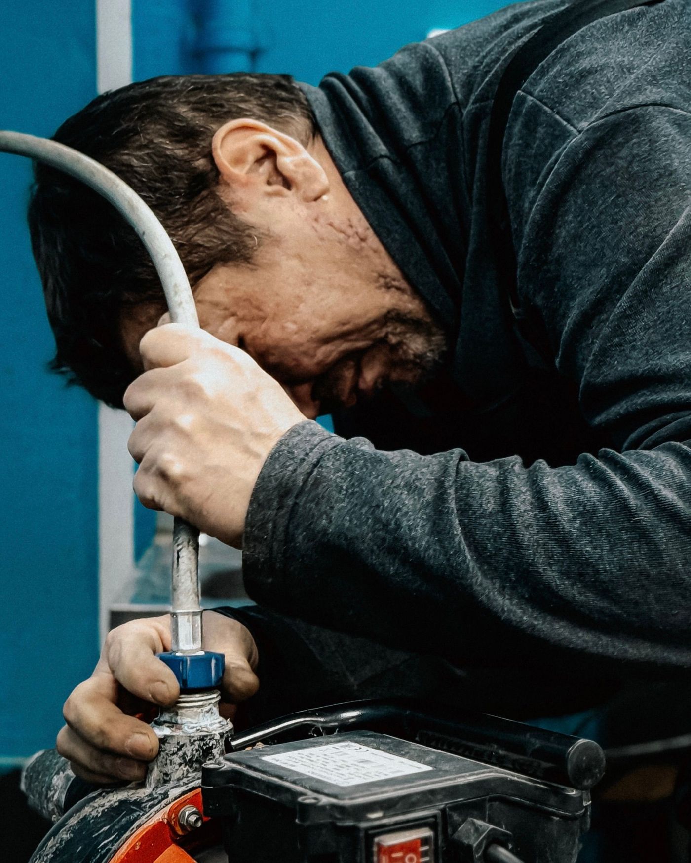 Plumber feeding a drain machine cable into a line