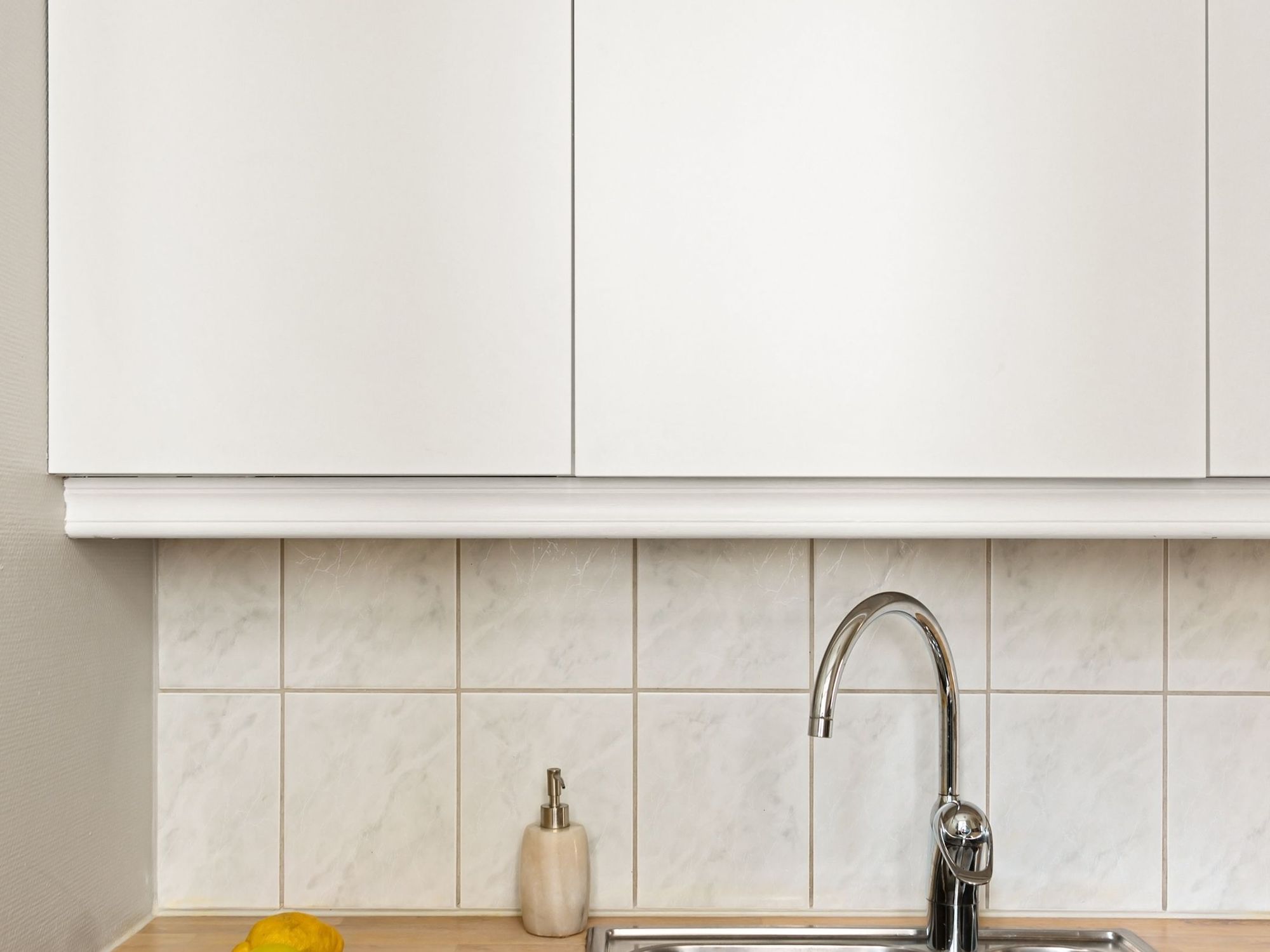 New chrome kitchen faucet against white tile