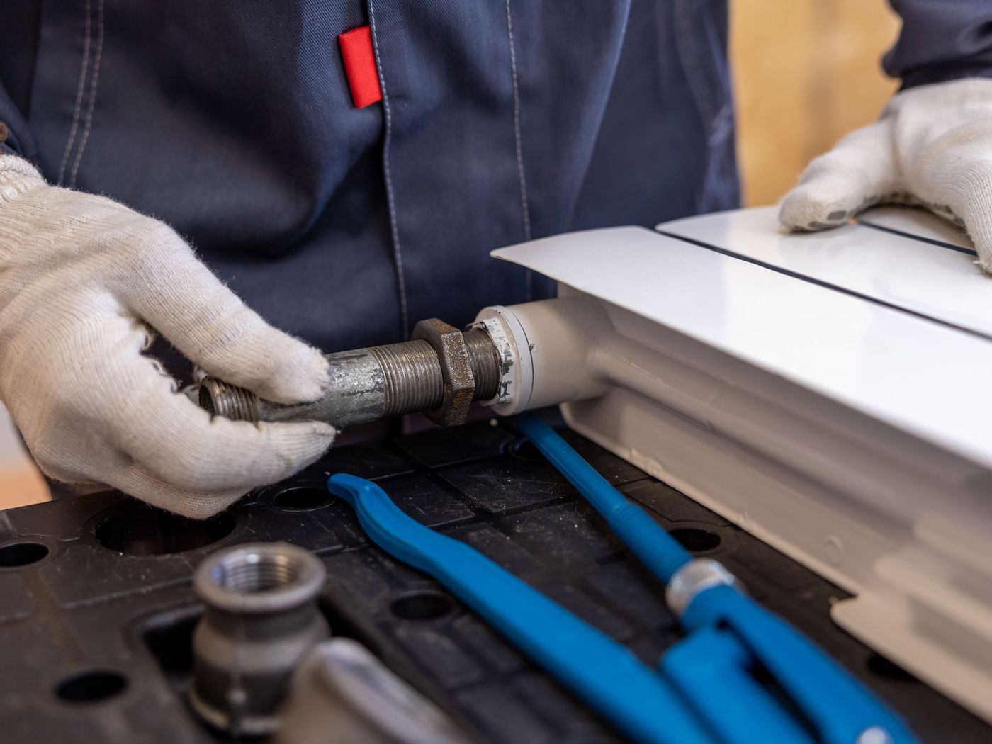 Plumber crimping a PEX fitting on a workbench