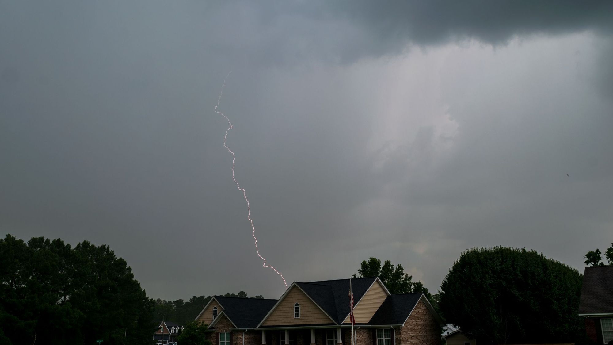 Lightning over a house at night